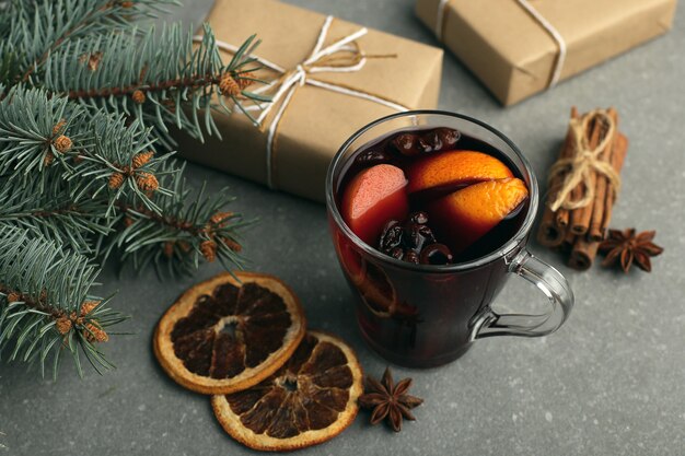 Vin chaud, cadeau et épices sur la table à côté de l'arbre