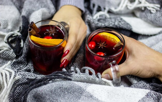 Vin chaud chaud dans les mains des hommes et des femmes, épices.