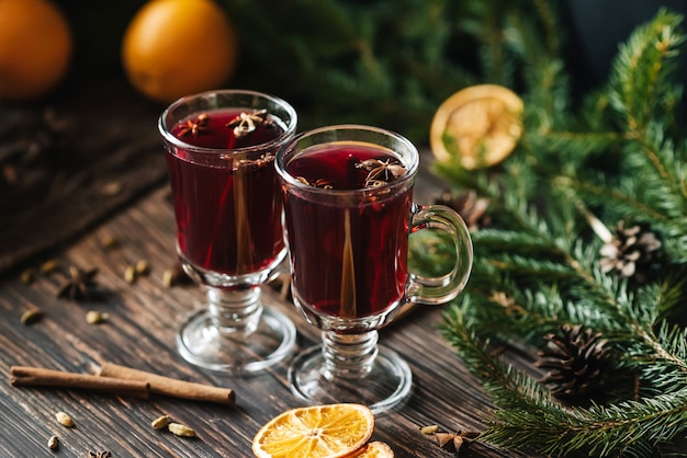 Vin chaud chaud fait maison avec décor de Noël et épices sur une table en bois