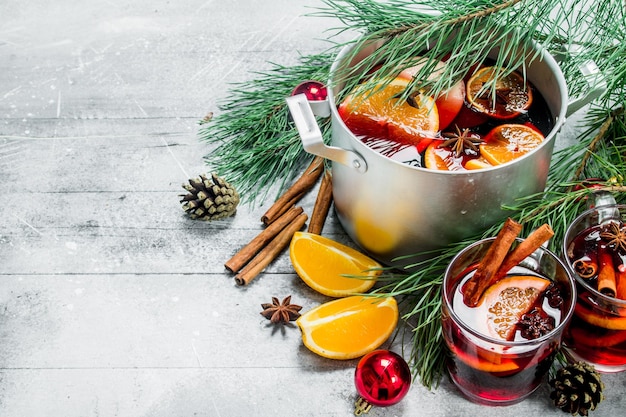 Vin chaud chaud de Noël dans un pot d'épices et d'herbes