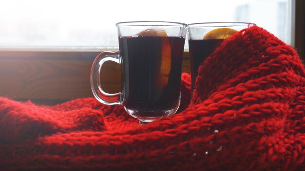 Vin chaud chaud pour l'hiver et Noël sur table en bois avec espace de copie. Vin rouge chaud avec foulard orange et rouge