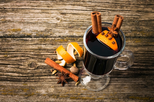 Vin chaud dans une coupe en verre sur une table en bois