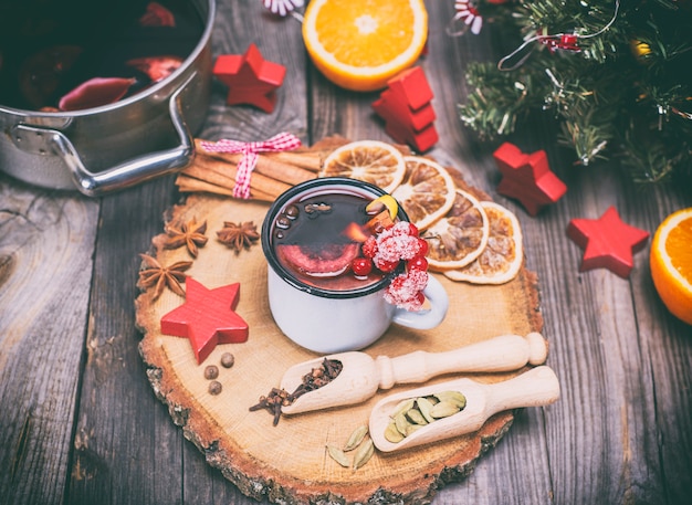 Vin chaud dans une tasse en fer et ingrédients