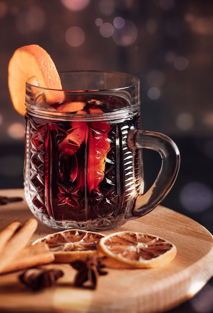 Vin chaud dans une tasse en verre. Boisson chaude de Noël avec des épices et des fruits.