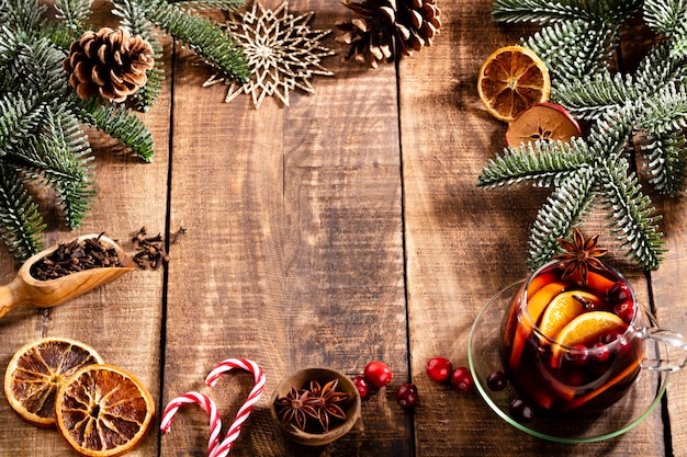 Vin chaud de Noël aux épices sur une table rustique en bois.