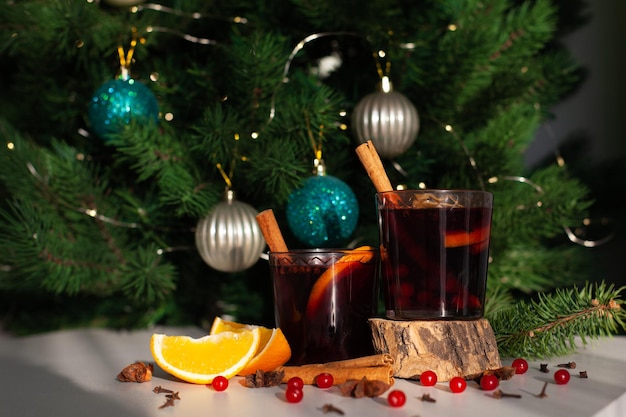 Vin chaud de Noël avec bâton de cannelle, orange, anis et clous de girofle avec les ombres du soleil sur fond blanc. Vacances d'hiver.