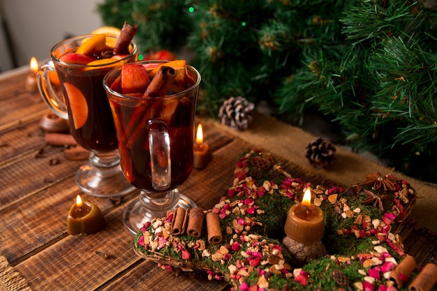 Vin chaud de Noël et bougies sur table en bois