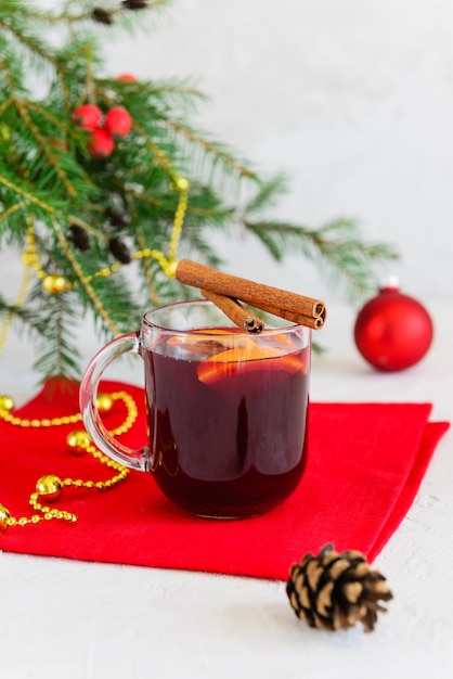 Vin chaud de Noël à la cannelle, anis, clous de girofle et orange dans une tasse avec un sapin de Noël.