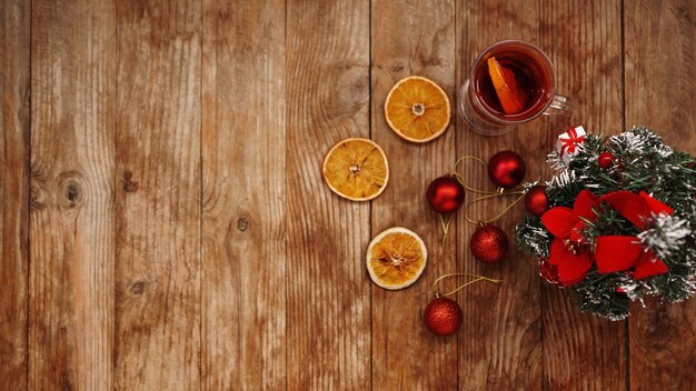 Vin chaud de Noël dans une tasse en verre sur une table en bois avec des oranges sèches