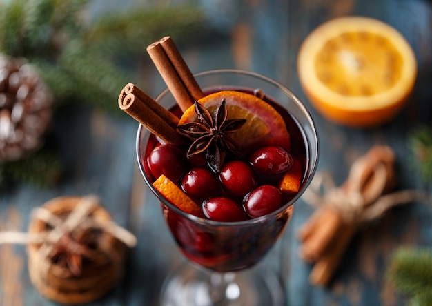 Vin chaud de Noël dans un verre d'épices, d'agrumes et de canneberges. Ambiance de Noël.