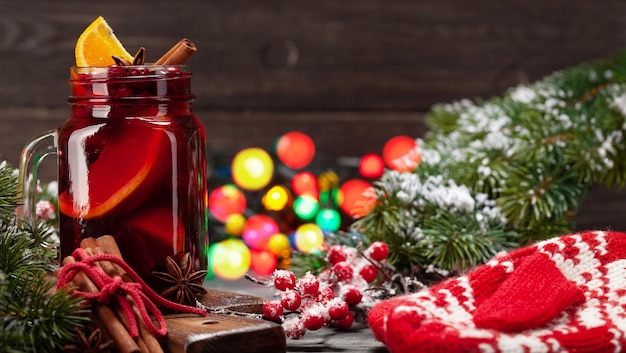 Vin chaud de Noël avec des épices et des agrumes arbre de Noël et des lumières bokeh