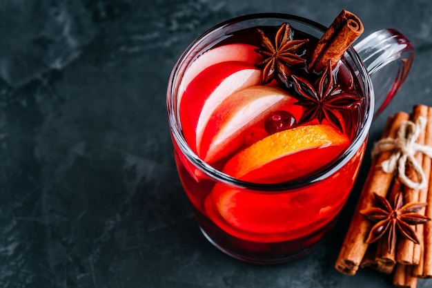 Vin chaud de Noël avec des épices et des fruits sur un fond sombre copie espace Boisson chaude traditionnelle pour Noël