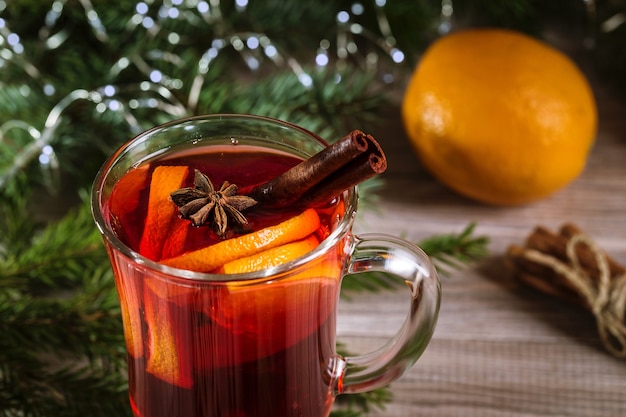 Vin chaud de Noël et mandarines sur un fond en bois.