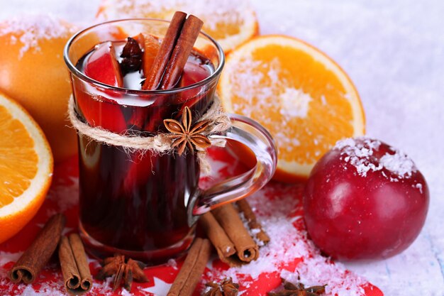 Vin chaud parfumé en verre sur gros plan de neige