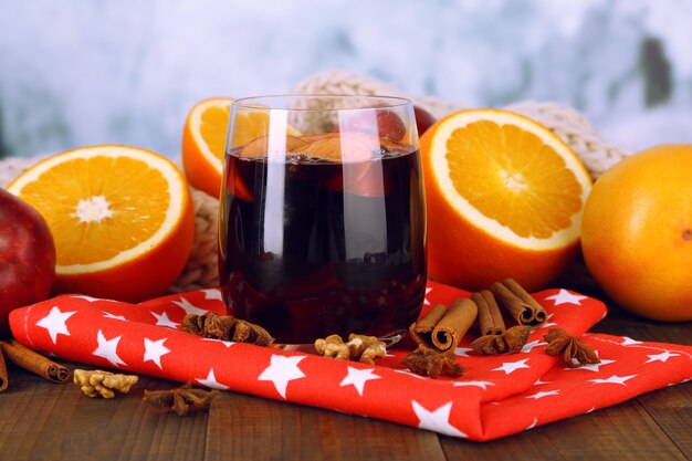 Vin chaud parfumé en verre sur une serviette sur fond d'hiver