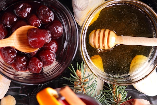 Vin chaud rouge miel d'abeille tranches d'oranges et d'épices sur un fond sombre décoration de Noël avec des branches d'épinette libre