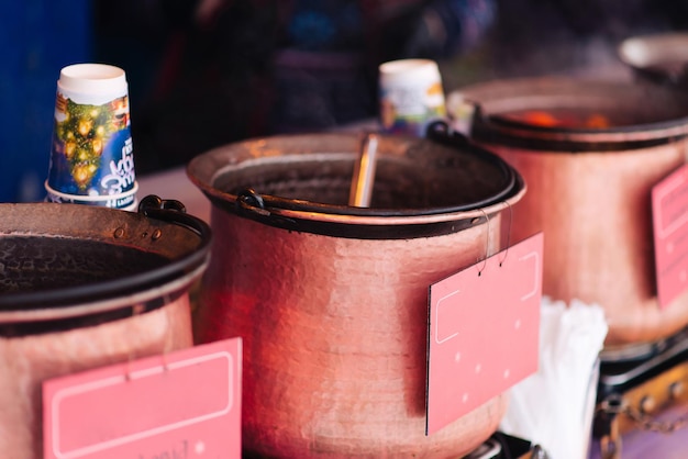 Vin chaud traditionnel, une boisson de rue d'hiver, préparée et chauffée dans une casserole en hiver dans une rue