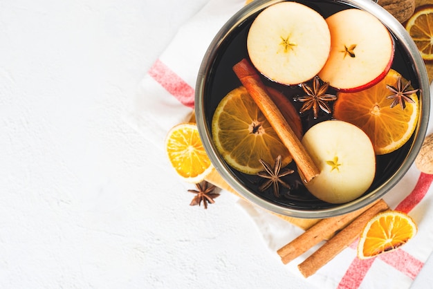 Vin chaud traditionnel en pot avec des épices sur blanc