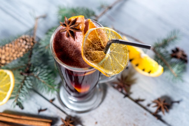 Un vin chaud en verre sur le fond en bois blanc