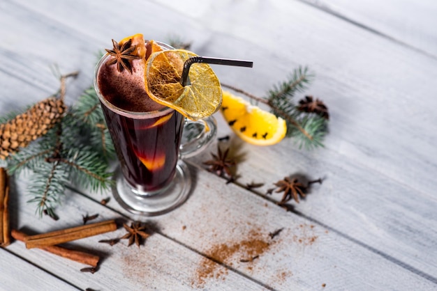 Un vin chaud en verre sur le fond en bois blanc