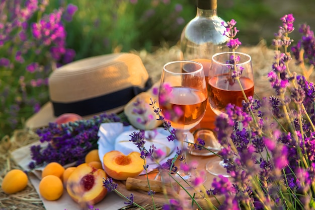 Vin dans des verres. Pique-nique dans le champ de lavande. Mise au point sélective. Nature.