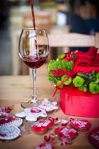 Le vin est versé dans un verre Bouquet rouge pour la Saint Valentin