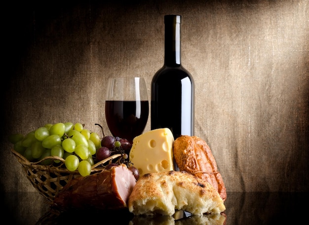 Vin, fromage, raisins et saucisses sur une vieille toile