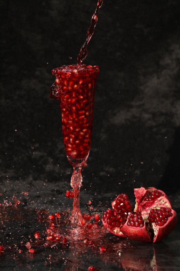 Photo vin de grenade dans le verre sur le fond noir