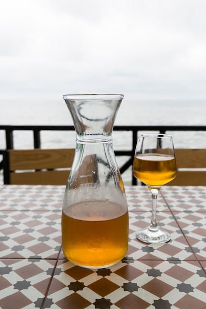 Vin d'orange de Kvevri. Batoumi, restaurant de Tbilissi au bord de la mer. Un pichet et deux verres. Sur fond de mer