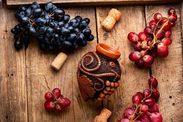 Photo vin de raisin jeune dans un récipient. beau flacon de vin avec du vin de raisin d'automne