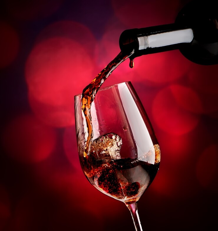 Vin rouge en bouteille et verre à vin sur fond vineux