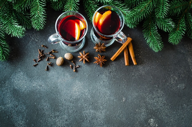 Vin rouge chaud aux épices sur béton foncé