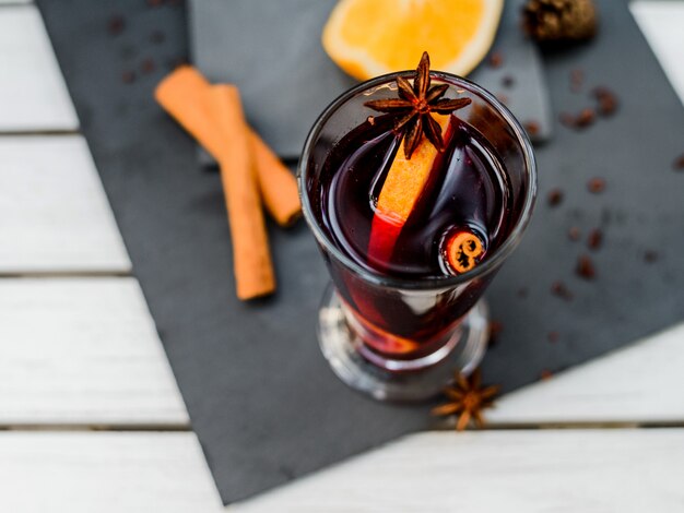 Vin rouge chaud avec des épices sur fond de pierre sombre. vue de dessus