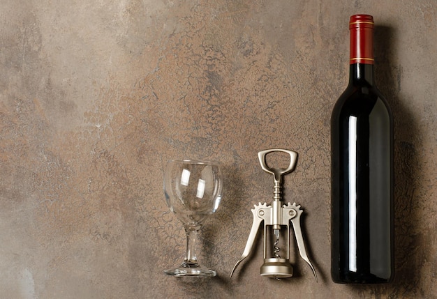 Photo vin rouge dans une bouteille fond de béton brun mise à plat copier l'espace