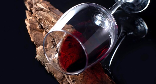 Vin rouge dans un verre bois vintage fond noir