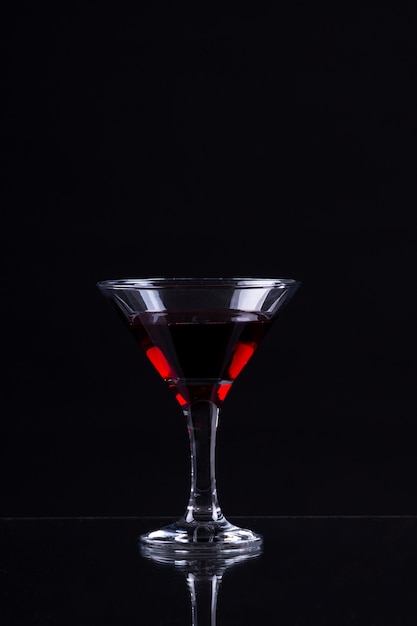 Vin rouge dans un verre de martini sur fond noir