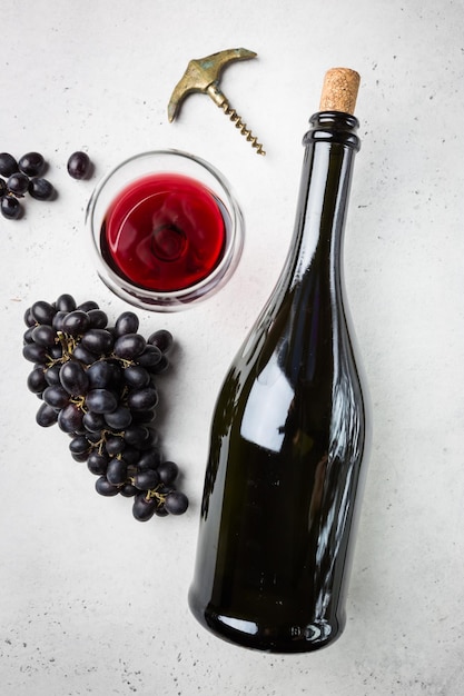 Vin rouge dans un verre et raisins mûrs sur fond blanc vue de dessus