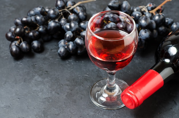 Vin rouge dans des verres, une grappe de raisin noir.