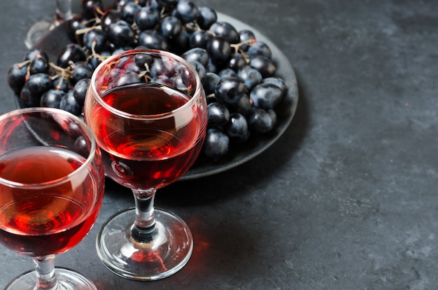 Vin rouge dans des verres, une grappe de raisin noir.