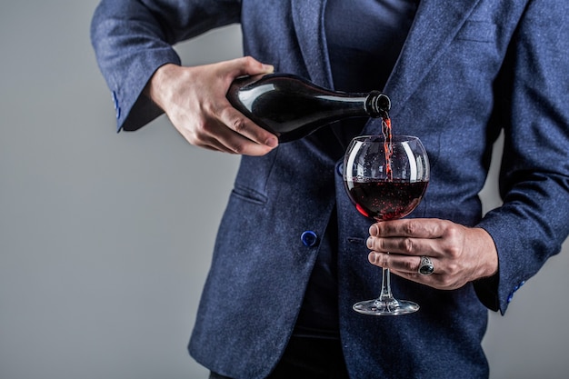 Le vin rouge est versé de la bouteille au verre