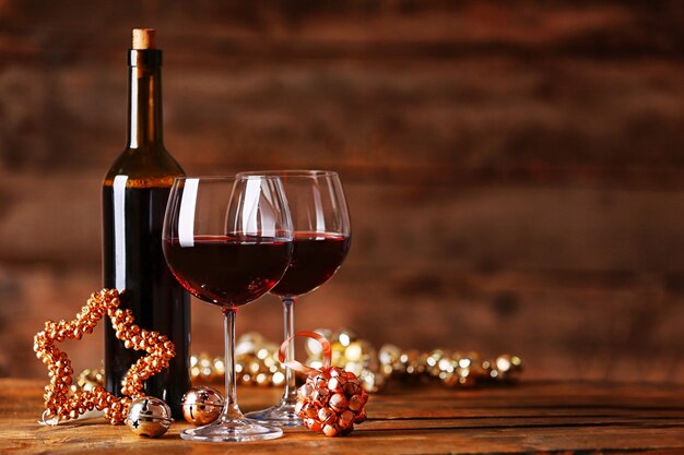 Vin rouge et ornements de Noël sur une table en bois sur une surface en bois