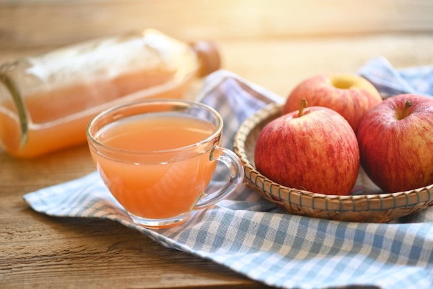 Vinaigre de cidre de pomme remèdes naturels et remèdes pour les problèmes de santé courants vinaigre de cidre de pomme biologique brut et non filtré en verre avec des pommes sur la table en bois