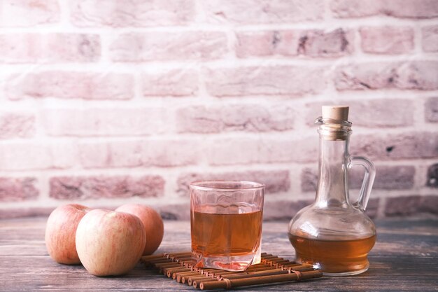 Vinaigre de pomme en bouteille de verre avec pomme verte fraîche sur table