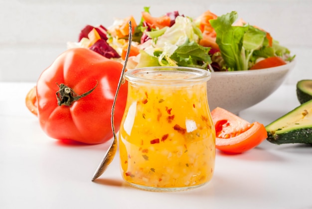 Vinaigrette italienne classique vinaigrette, avec des légumes frais sur une table en marbre blanc,