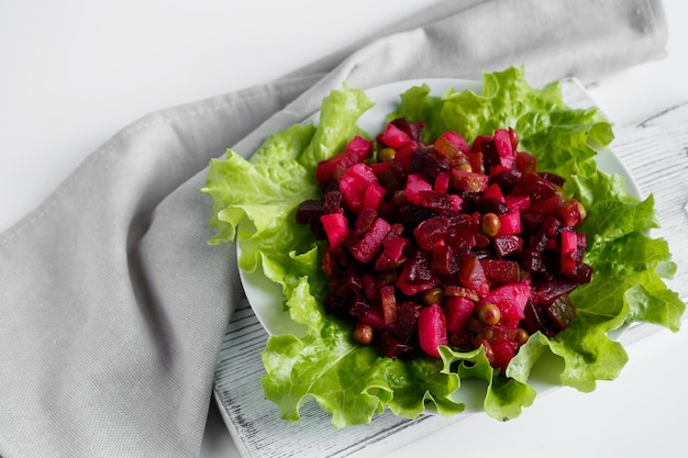 Vinaigrette de salade russe sur fond gris. Plat végétarien aux betteraves sur une assiette.