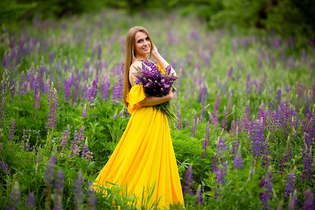 Vinnytsia Ukraine 17 juin 2022 femme ukrainienne en robe jaune avec un bouquet de lupins