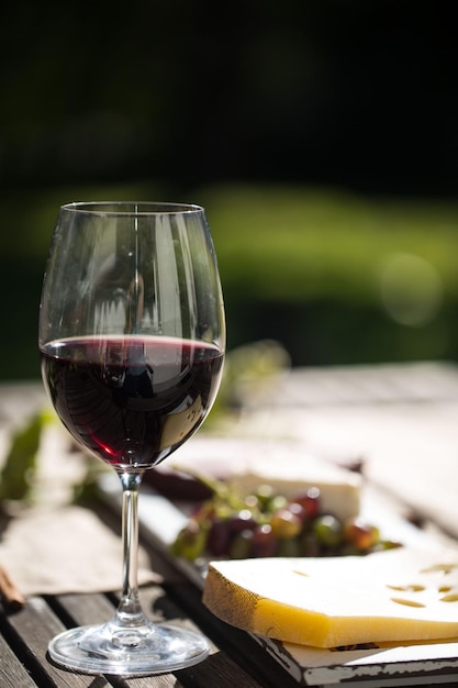 Vins rouges et fromages en gros plan sur une table en bois