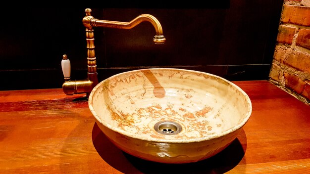 Vintage Beau robinet et mitigeur doré sur un lavabo rond en marbre dans la salle de bain. Intérieur d'une toilette chère avec un lavabo en marbre.