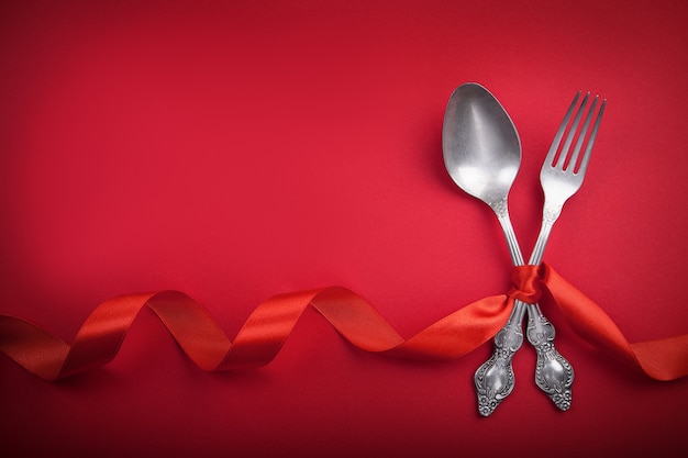 Vintage cuillère et une fourchette avec un ruban rouge pour la Saint-Valentin.