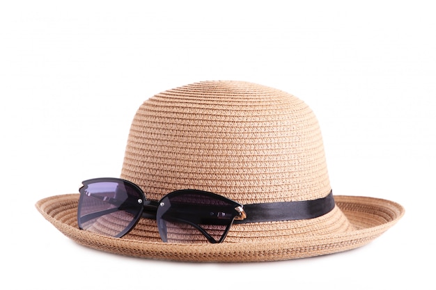 Vintage fabrique un chapeau de paille et des lunettes de soleil isolés sur blanc.